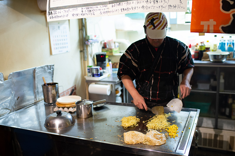 Chef making Hiroshima style okonomiyaki in restaurant Hiroshima