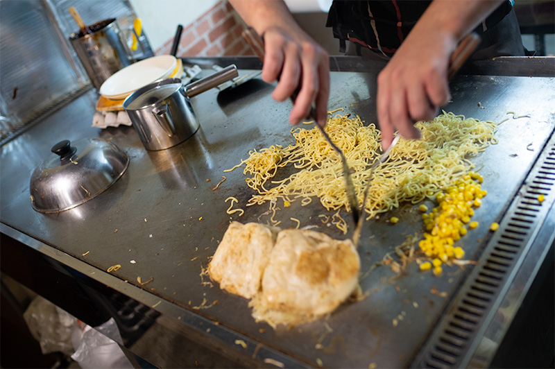 Chef making Hiroshima style okonomiyaki in restaurant Hiroshima