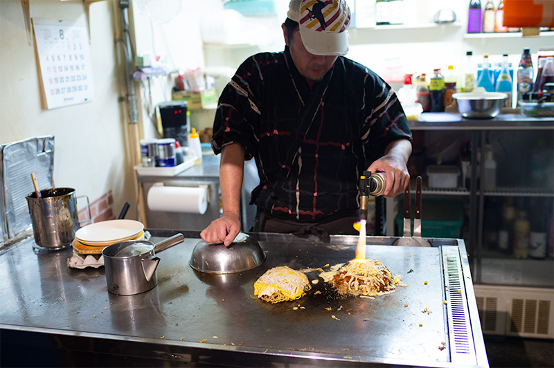 Chef making Hiroshima style okonomiyaki in restaurant Hiroshima