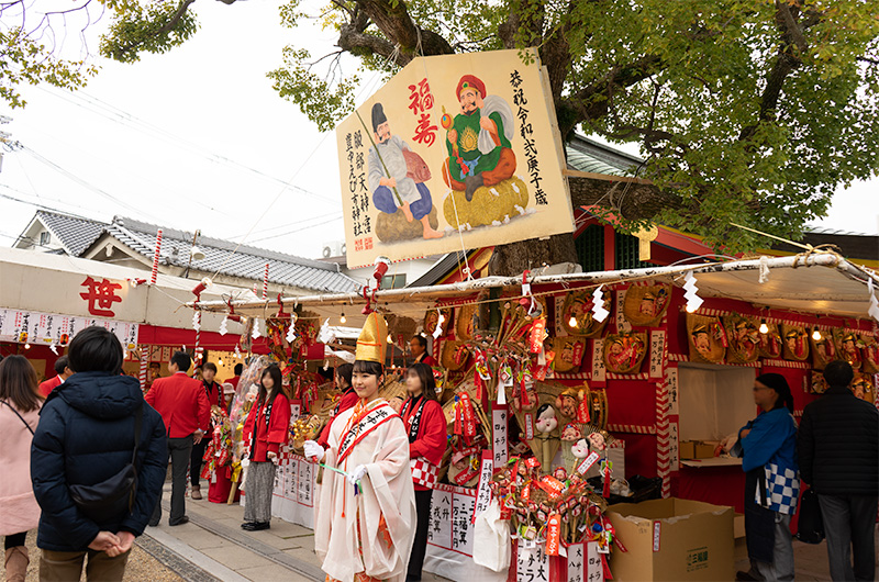 Shrine maiden and lucky charms in festival of God Ebisu Toyonaka at Hattori Shrine