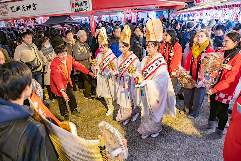 Shrine maiden ringing bell in festival of God Ebisu Toyonaka at Hattori Shrine