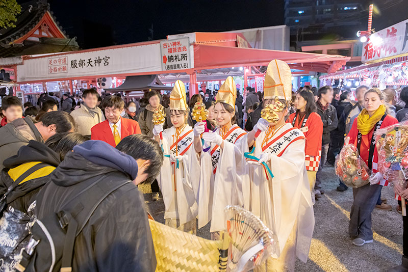 Shrine maiden ringing bell in festival of God Ebisu Toyonaka at Hattori Shrine